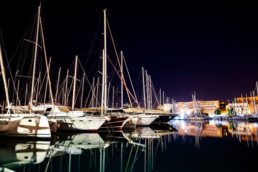 Moored boats and yachts at night in a harbor in Palermo, Sicily