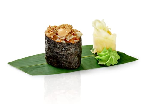 Gunkan maki sushi with eel seasoned with spicy sauce and sesame, presented with wasabi and pickled ginger on bamboo leaf, isolated on white background. Traditional Japanese cuisine