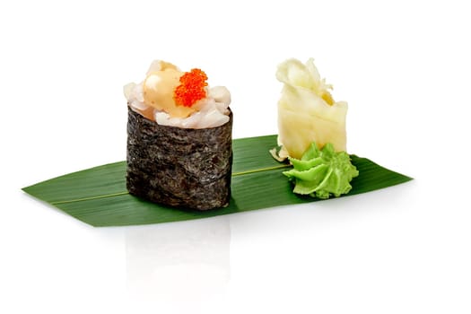 Japanese gunkan maki sushi, with ocean perch and tobiko drizzled with spicy sauce, served on bamboo leaf, accompanied by wasabi and pickled ginger, isolated on white