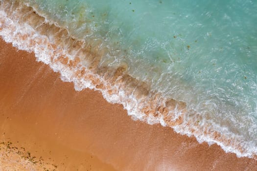 Aerial drone overhead view of beautiful waves on sand.