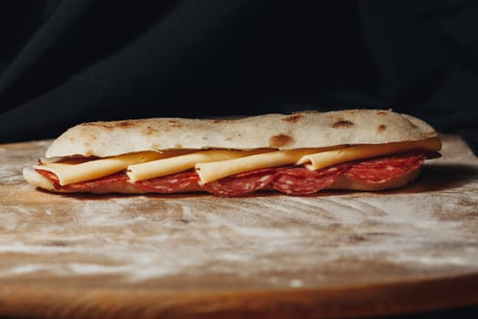 Artisanal Pepperoni andA close-up view of a freshly made pepperoni and cheese sandwich on rustic bread, resting on wood. Cheese Sandwich on a Wooden Cutting Board. High quality photo
