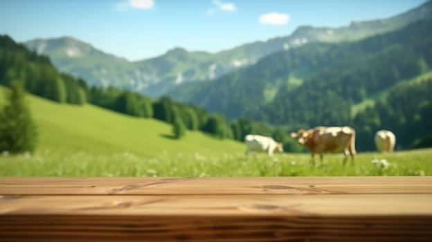 Wooden table foreground with alpine meadow and cows with mountain backdrop. Rural life and eco-tourism concept. Cow walking and eating grass at animal farm with green mountain and blue sky. AIG35.