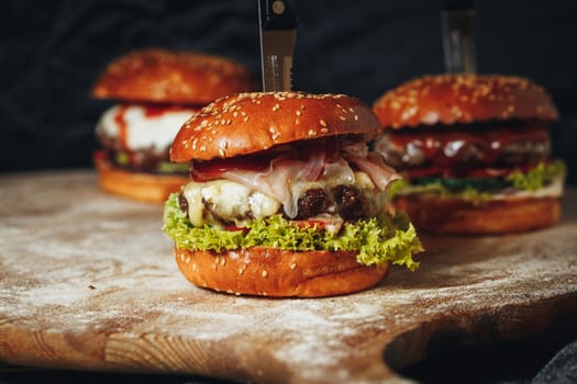 Three juicy, cheese-topped beef burgers with lettuce and tomato, ready to be enjoyed.