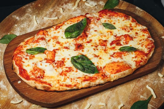 Handcrafted Heart-A heart-shaped Margherita pizza with melted cheese and basil on a wooden cutting board.Shaped Margherita Pizza on Wooden Board, Garnished With Fresh Basil Leaves. High quality photo