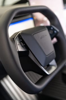Denver, Colorado, USA-May 5, 2024-This image features a detailed close-up of the unique, minimalist steering wheel design of a Tesla Cybertruck, highlighting its sleek controls and futuristic aesthetic typical of Tesla innovative approach to vehicle design.