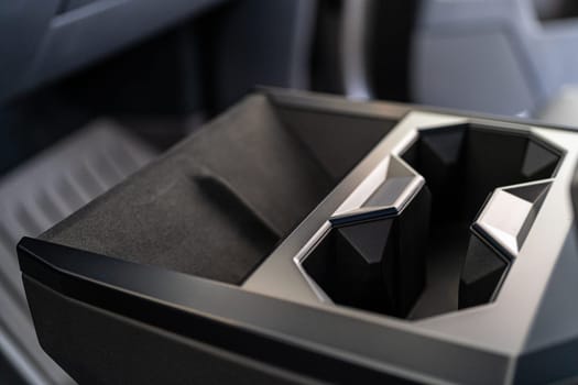 Denver, Colorado, USA-May 5, 2024-This image captures the innovative design of the cupholder inside the Tesla Cybertruck, showcasing its unique angular shapes and modern, minimalist aesthetic.