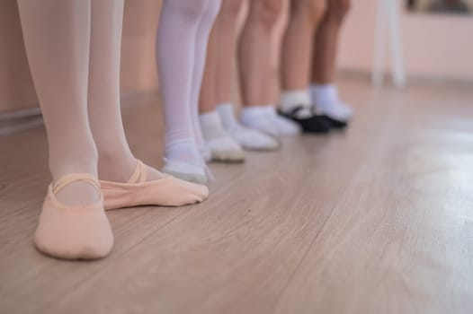 Close-up of feet of 5 little girls and teacher at ballet class