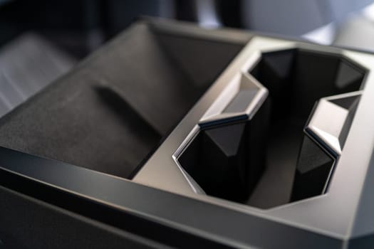 Denver, Colorado, USA-May 5, 2024-This image captures the innovative design of the cupholder inside the Tesla Cybertruck, showcasing its unique angular shapes and modern, minimalist aesthetic.