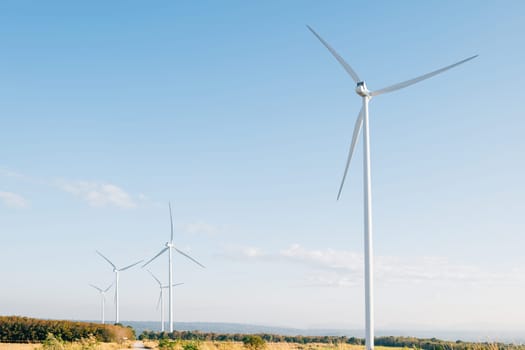 Nature meets technology, turbines on a mountain farm harness wind power for clean electricity. A modern windmill industry supporting sustainable development.