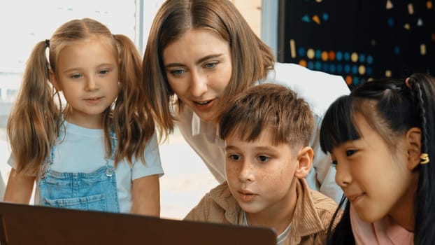 Smart teacher checking student answer while learner using laptop to doing homework, analysis data, programing engineering code and prompt, studying computer system at STEM technology class. Erudition.