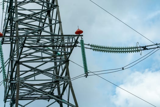 High voltage towers with sky background. Power line support with wires for electricity transmission. High voltage grid tower with wire cable at distribution station. Energy industry, energy saving.