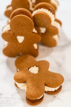Gingerbread cookies filled with eggnog buttercream stand out, their rich hue complementing the eggnog buttercream, against a gentle background. These festive treats exude a homemade allure.
