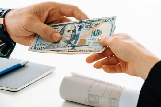 Businessman hand sending money to another business person. Transaction, payment, salary and banking concept. uds
