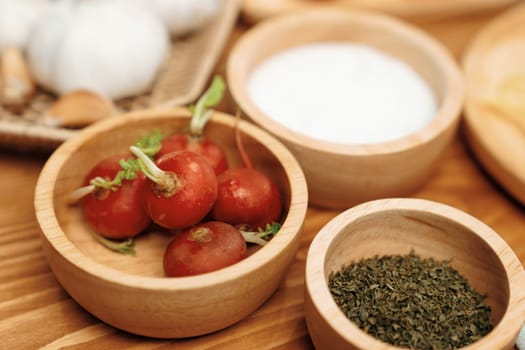 Close up in health food's Ingredients of special menu homemade cooking radish, garlic, salt, oregano, tomato and seasonings placing elements on preparing wooden table on blurred background. Postulate.