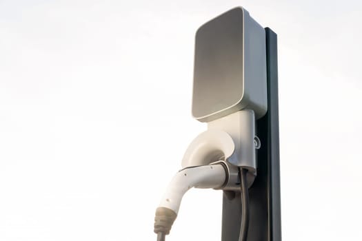 Backlit EV charging station at sunset or sunrise sky lighting, symbolizing the dawn of future eco-friendly transportation powered by clean and sustainable energy for natural protection. Exalt