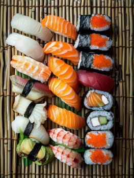 Japanese sushi platter with an assortment of nigiri and sashimi, beautifully arranged on a bamboo mat. A traditional Japanese dish showcasing the art of sushi making