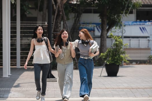 Group of happy students walking along the corridor at college.