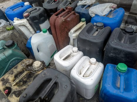 many used plastic containers standing closely on the ground