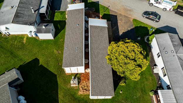 An Aerial View of a Manufactured, Mobile, Prefab Double Wide Home Being Installed in a Lot in a Park