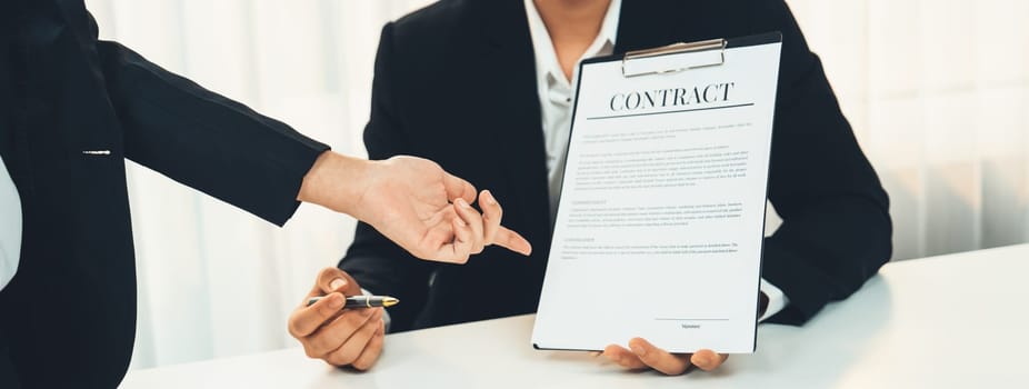 Business executive signing contract agreement document on the bale with the help from company attorney or lawyer service in law firm office. Business investing and finalizing legal processing. Shrewd