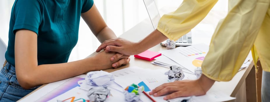 Panorama startup employee holding hand to stressed colleague due to failure, frustrated from no inspiration, lack of idea. Exhausted from overwhelm work and supportive coworker concept. Synergic