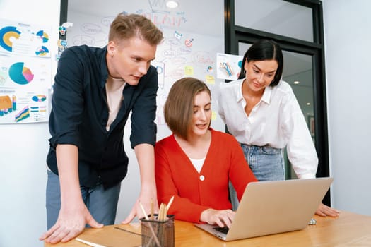 Professional business team working together by using laptop in start up project at meeting in front of glass board with mind map while colleague brainstorm and discuss about strategy. Immaculate.