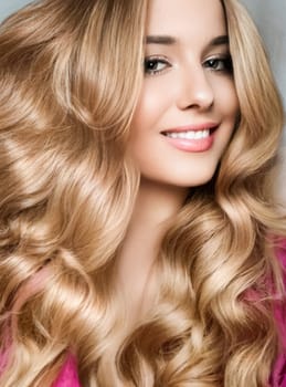 Beautiful blonde woman with curly volume hairstyle, long luxurious hair and beauty makeup, glamorous look face portrait for luxury fashion and natural cosmetics idea