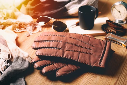 Pair of men's brown leather gloves and other men's accessories.