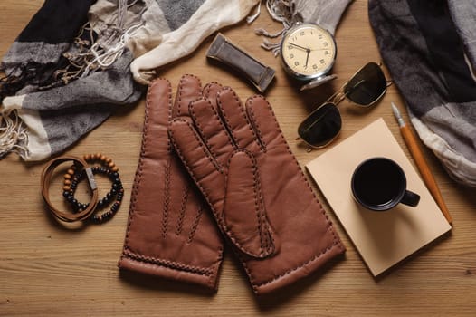 Pair of men's brown leather gloves and other men's accessories.