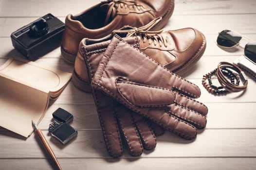 Pair of men's brown leather gloves and other men's accessories.