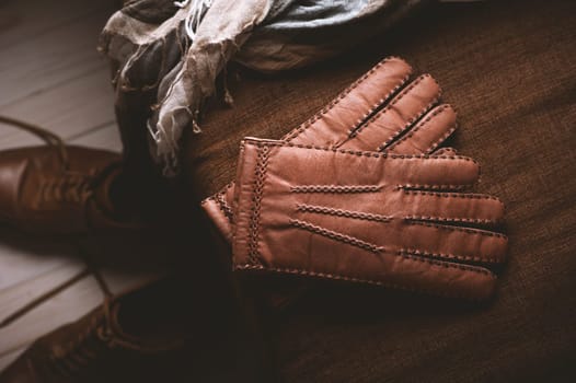 Pair of men's brown leather gloves and other men's accessories.