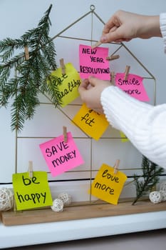 Woman creating dream board promises and aims. Preparation for new year new life new me. Visualizing wish list for 2025. Dreams plan action resolutions for coming year. Inspirational self improvement concept