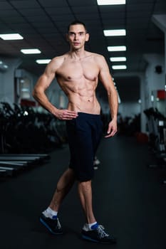 Shirtless man with sculpted body in the gym