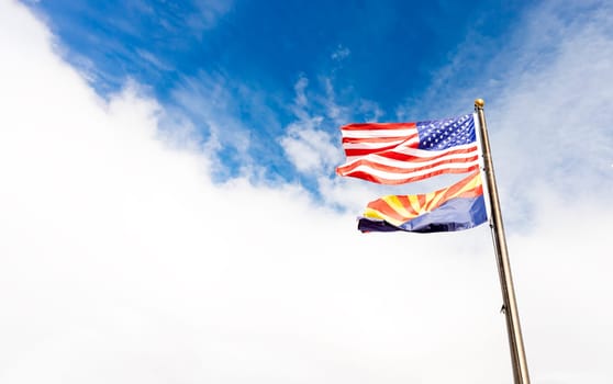 Design Waving American USA Flags and Flag of Arizona State on Flagpole On Background Of Blue White Sky, Template Horizontal Plane, Copy Space. High quality photo