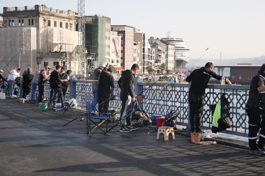 Turkey istanbul 12 january 2024. Fishermen fishing with fishing rods from the Galata Bridge ,