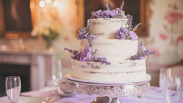 Wedding table decoration with lavender flowers, sweets, cake and candles