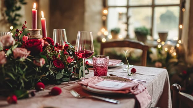 Festive table setting with cutlery, candles and beautiful red flowers in a vase.