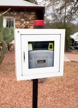Aed, Life Saving Defibrillator In Street. Portable Automated External Defibrillator Outdoor. Cactus Is On Background. Vertical Plane. Prevention Of Heart Attack. Cardiac Healthcare. High quality photo