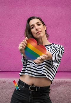 Body front view portrait of transgender lesbian woman with a rainbow heart to support LGBT community.