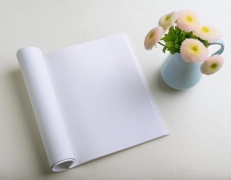 Office table with empty notebook and flower vase