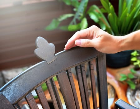 Garden chair with brush in protective gloves. Worker paints garden furniture. Renewal, renovation of wooden garden furniture