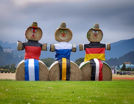 Funny figures made of straw bales on the background of a winter forest and field