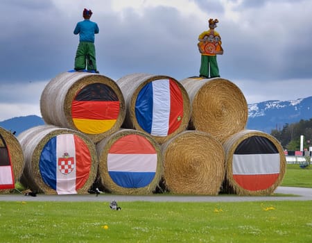 Funny figures made of straw bales on the background of a winter forest and field