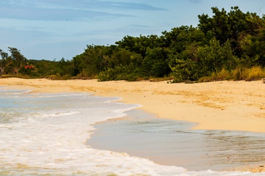 Caribbean beach with white sand, deep blue sky and turquoise water