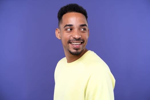 Emotional young black guy in casual raising fists up studio background, celebrating success, happy handsome african american millennial man sharing good emotions, copy space