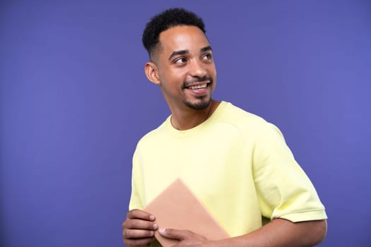 Emotional young black guy in casual raising fists up studio background, celebrating success, happy handsome african american millennial man sharing good emotions, copy space