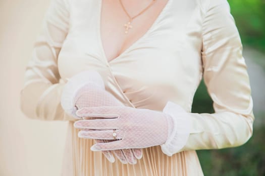 Elegant woman in an old dress and gloves.
