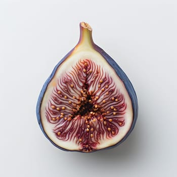 A fig, an accessory fruit of a flowering plant, cut in half on a white background. This natural food ingredient is a staple produce from a terrestrial plant