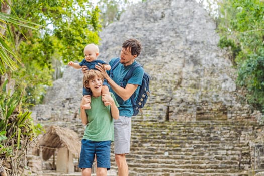Dad with two sons tourists at Coba, Mexico. Ancient mayan city in Mexico. Coba is an archaeological area and a famous landmark of Yucatan Peninsula. Cloudy sky over a pyramid in Mexico.