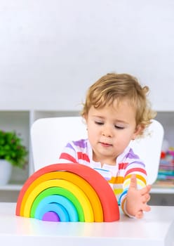 The child collects the constructor rainbow. Selective focus. Kid.